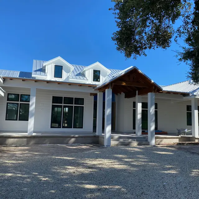 White coastal home with metal roof and freshly painted front porch