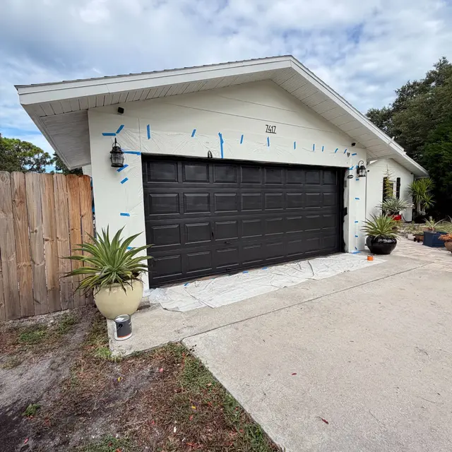 Detached garage with a newly painted dark garage door