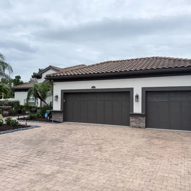 Same home after repainting in white with charcoal garage doors