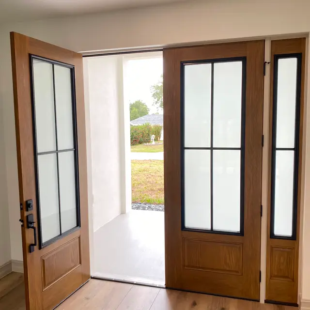 Stained wood front doors and sidelight seen from the entry hall