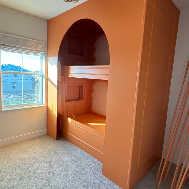 Arched bunk nook finished in a burnt-orange paint